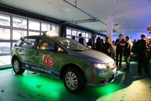BYD heeft met zijn e6 de eerste elektrische taxi's voor Rotterdam geleverd. Wethouder van Huffelen neemt plaats in de groene taxi.
